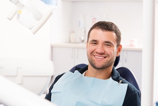 A happy man without dental insurance at dentist